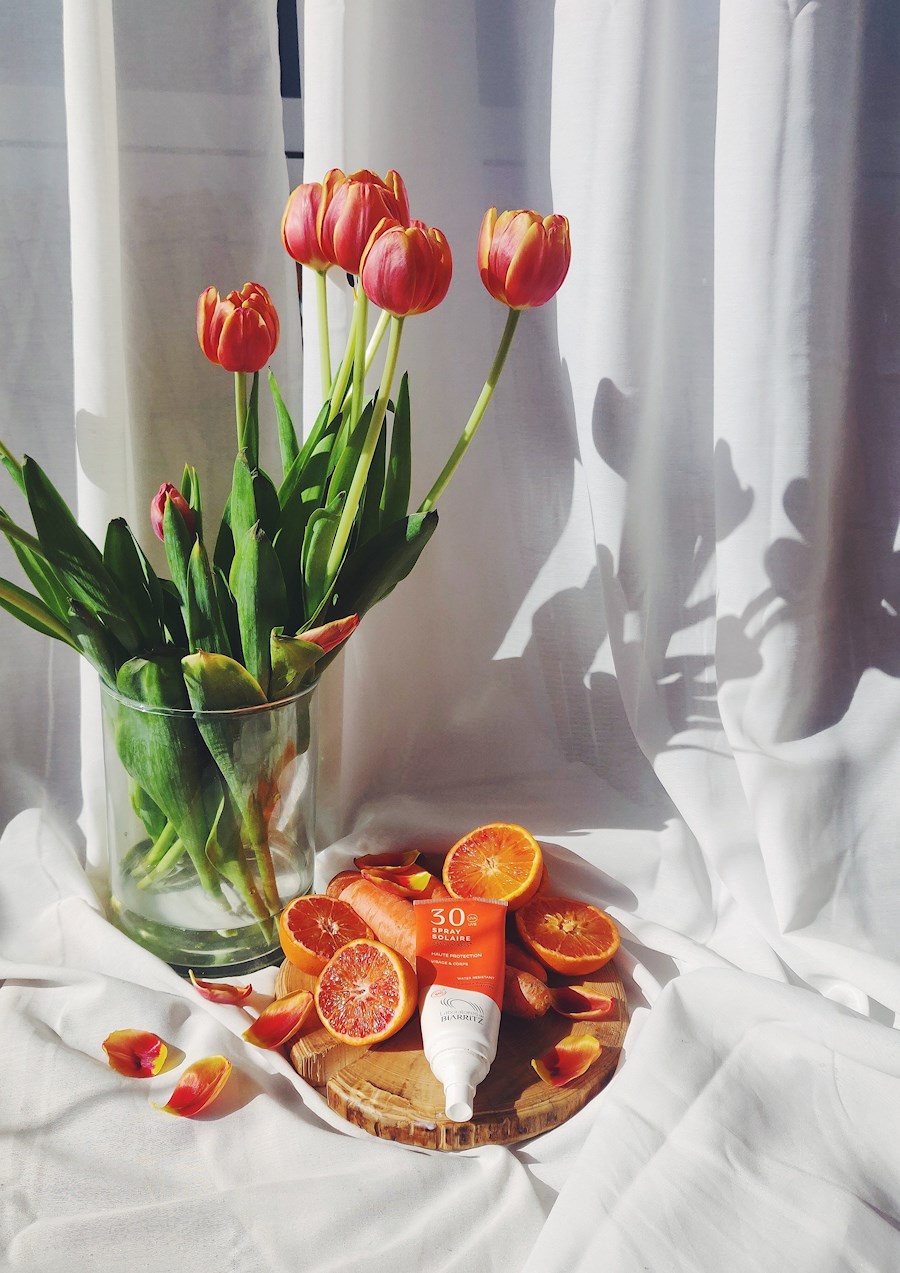 Stillborn with white curtain, orange tulips, oranges, carrots and Alga Maris sunscreen